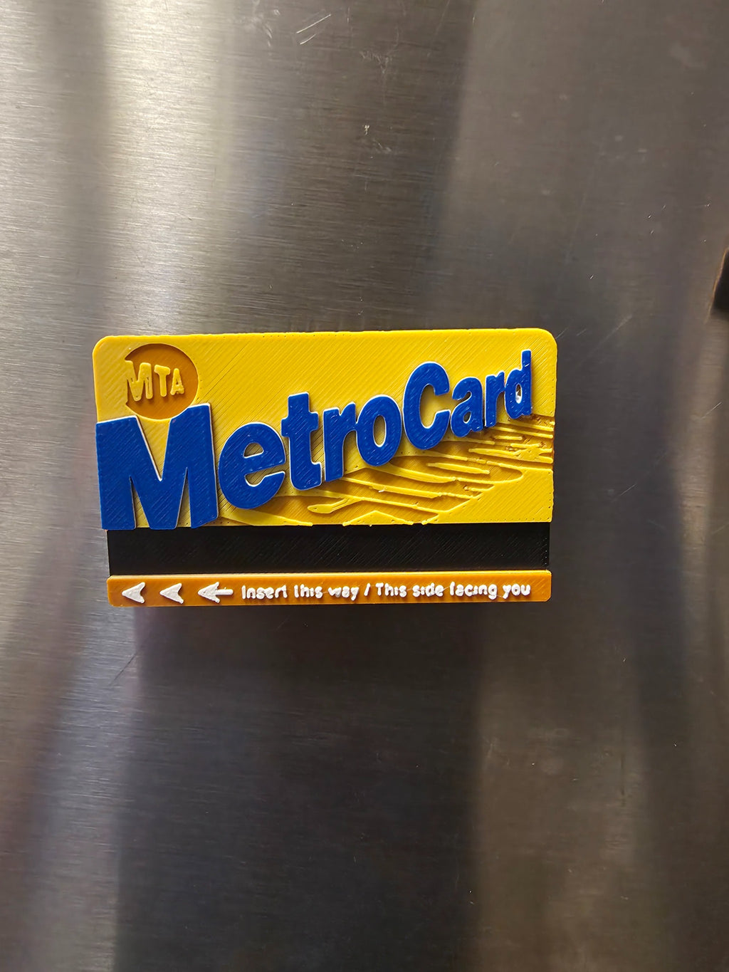 Close-up product photo of NYC transit card inspired 3D printed refrigerator magnet
